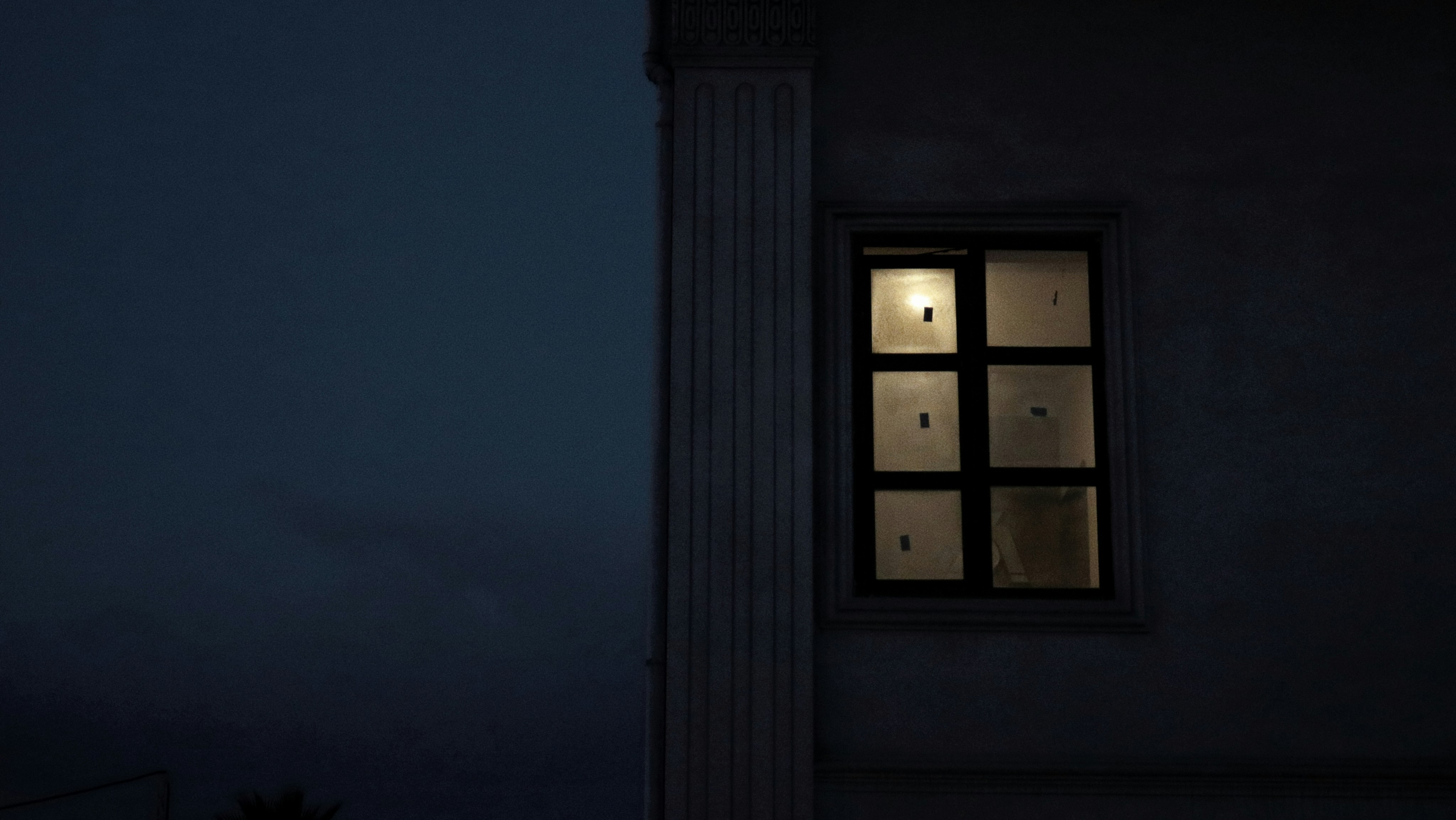 A building with a lit up window at night