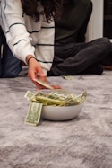 A woman reaching for money in a bowl