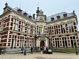 A large building with many windows and people walking around