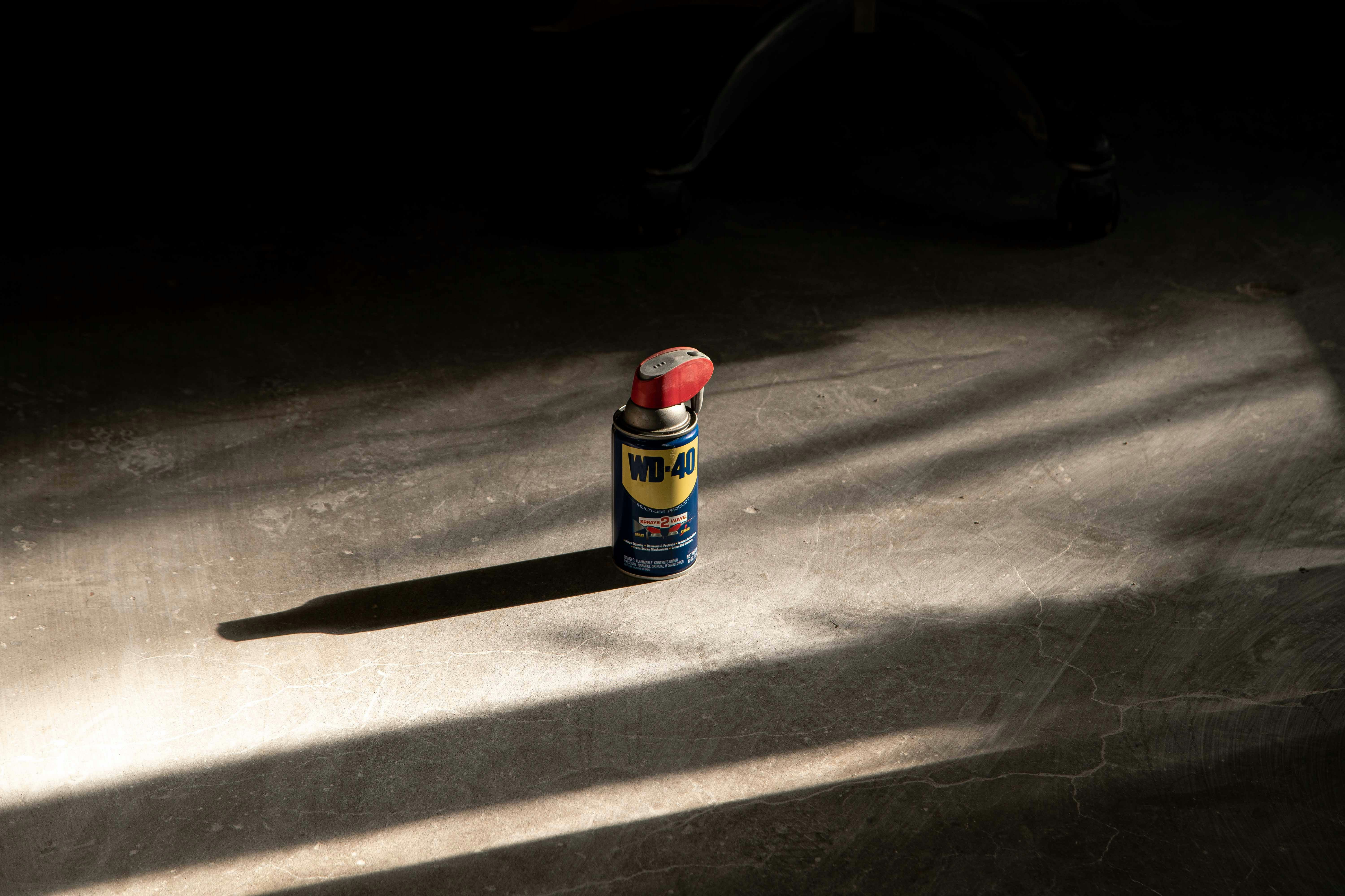 A bottle of glue sitting on the ground in the dark