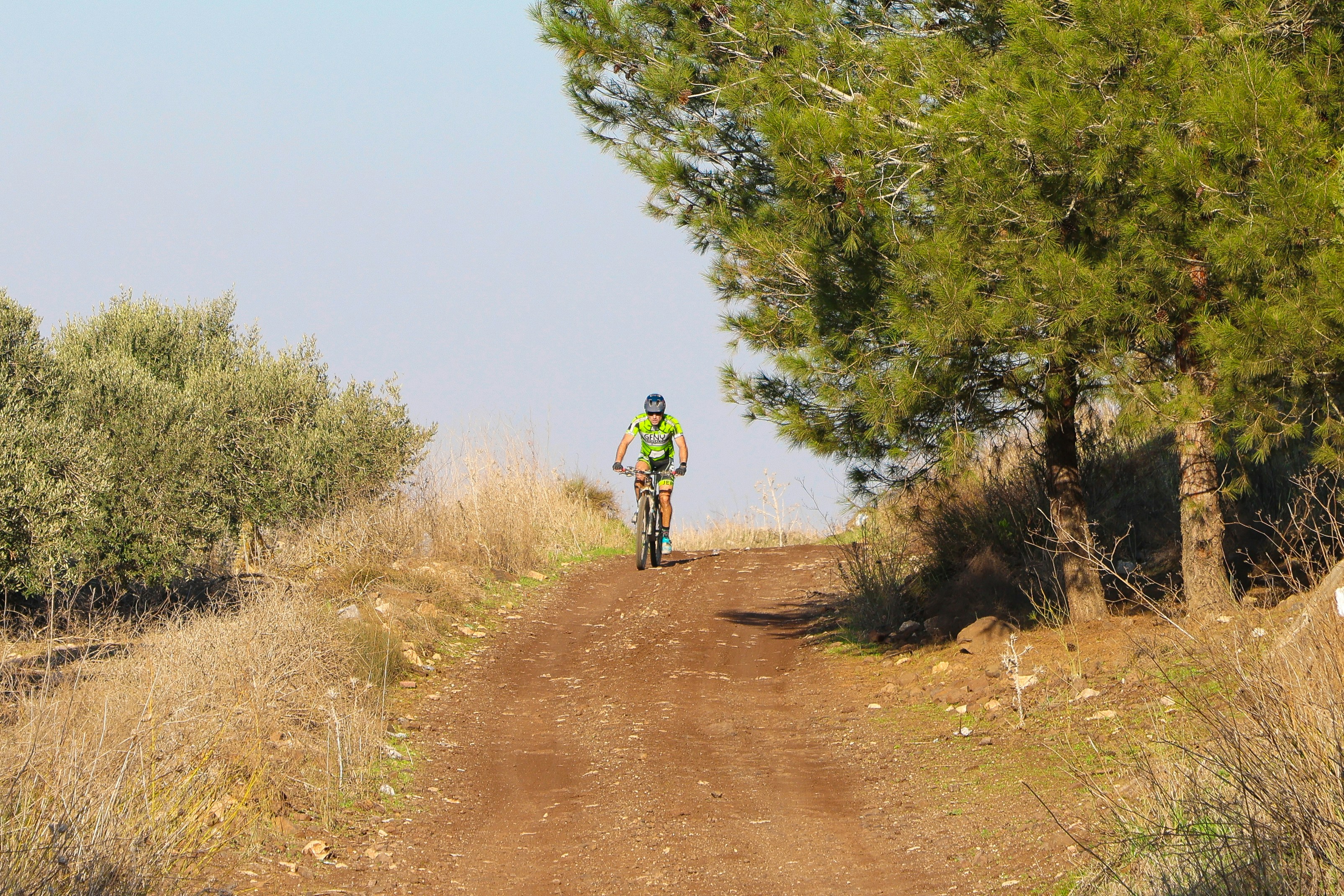 A man riding a bike down a dirt road