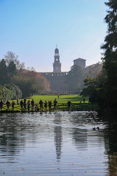 A group of people standing on the edge of a lake