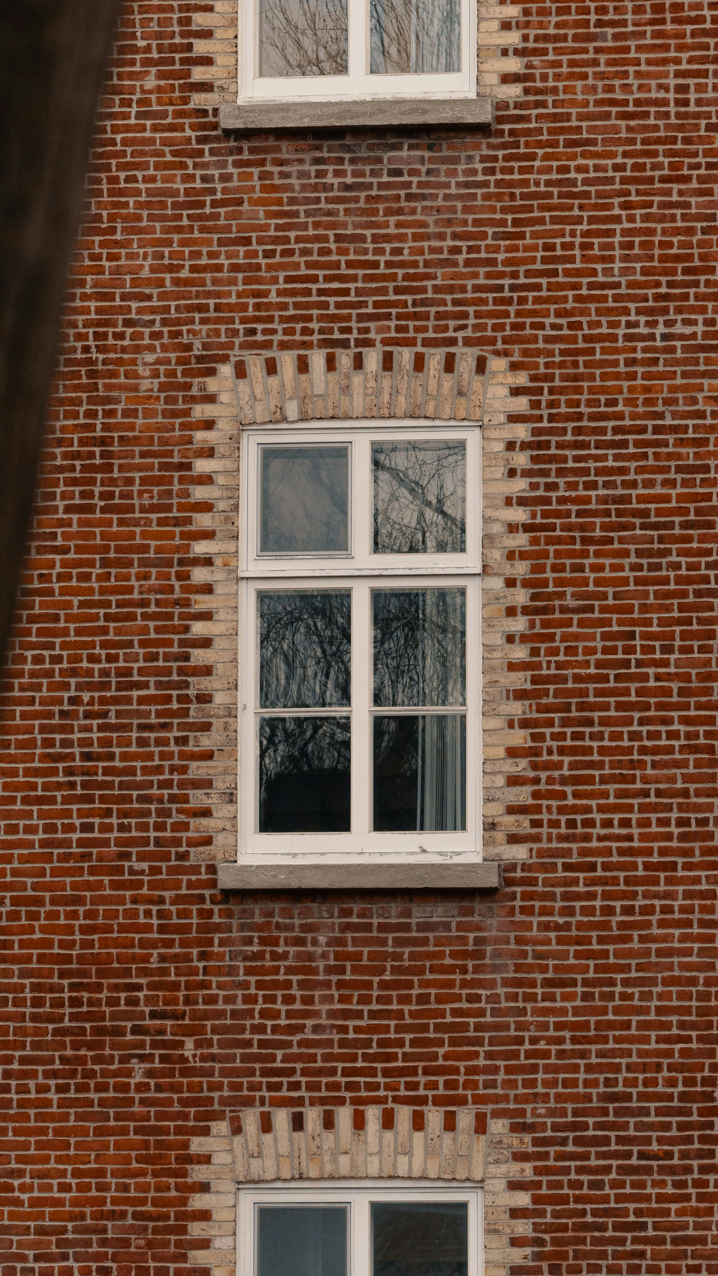 A red brick building with two windows and a clock