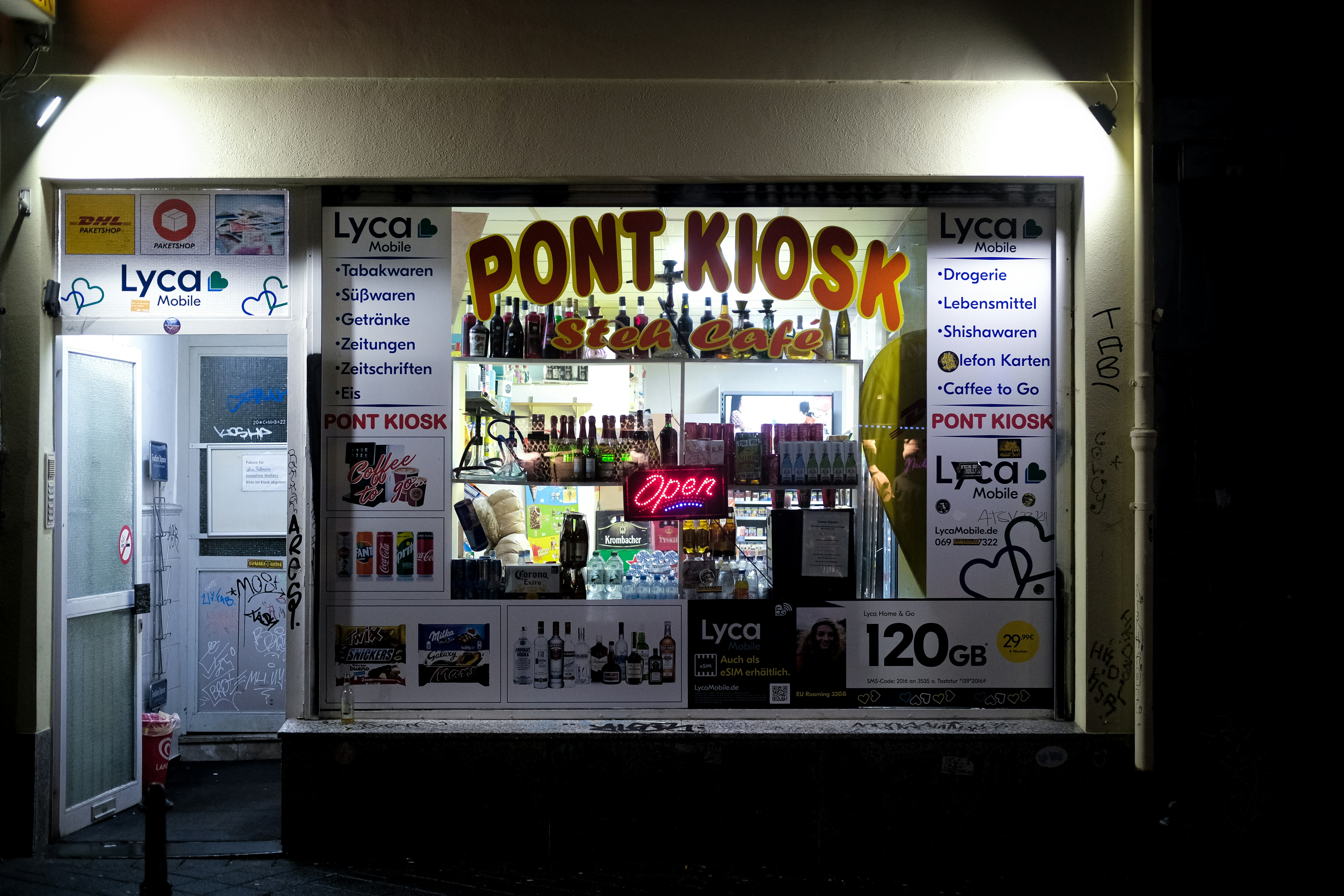 A store front with a lit up sign in the window