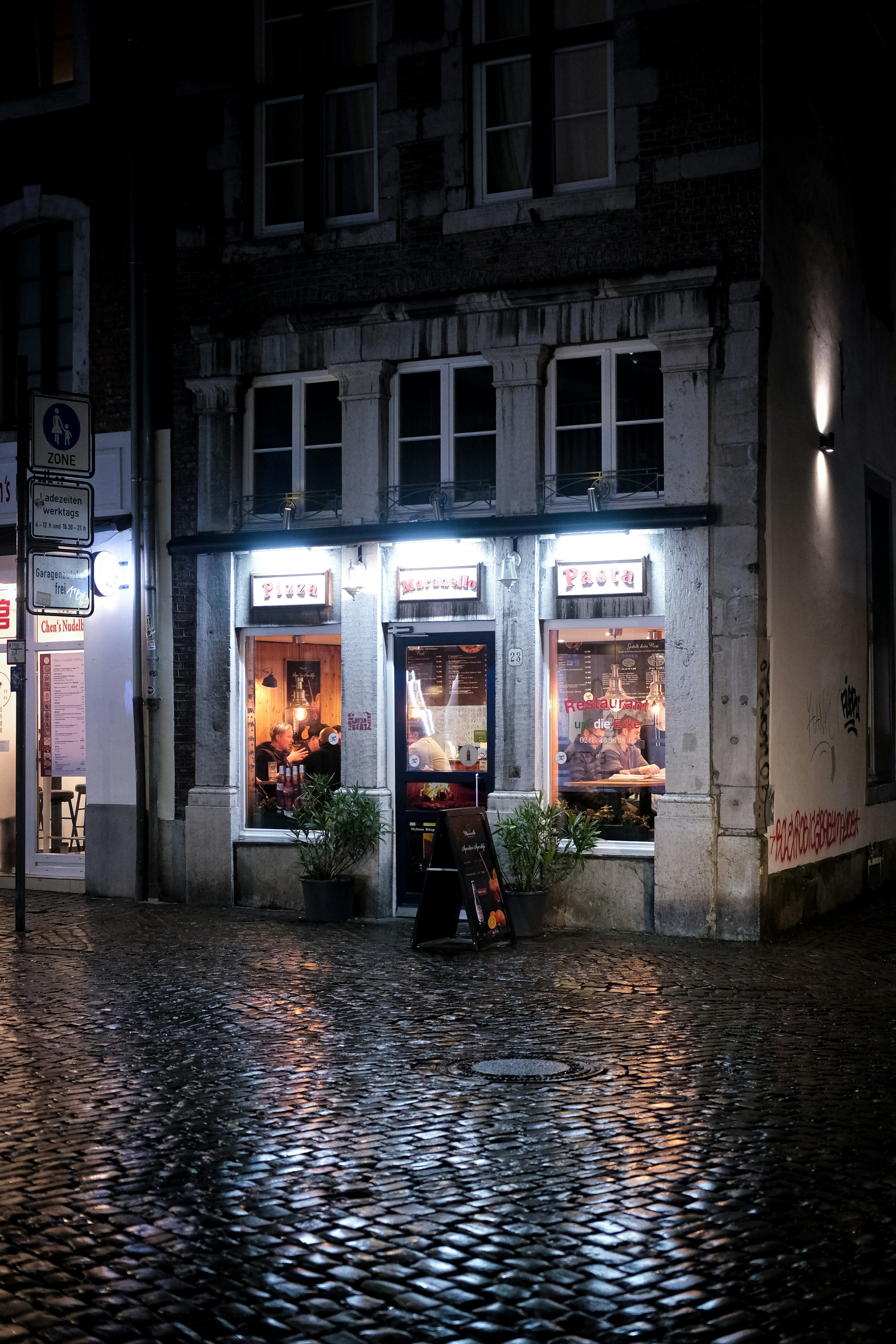 A cobblestone street in front of a building at night