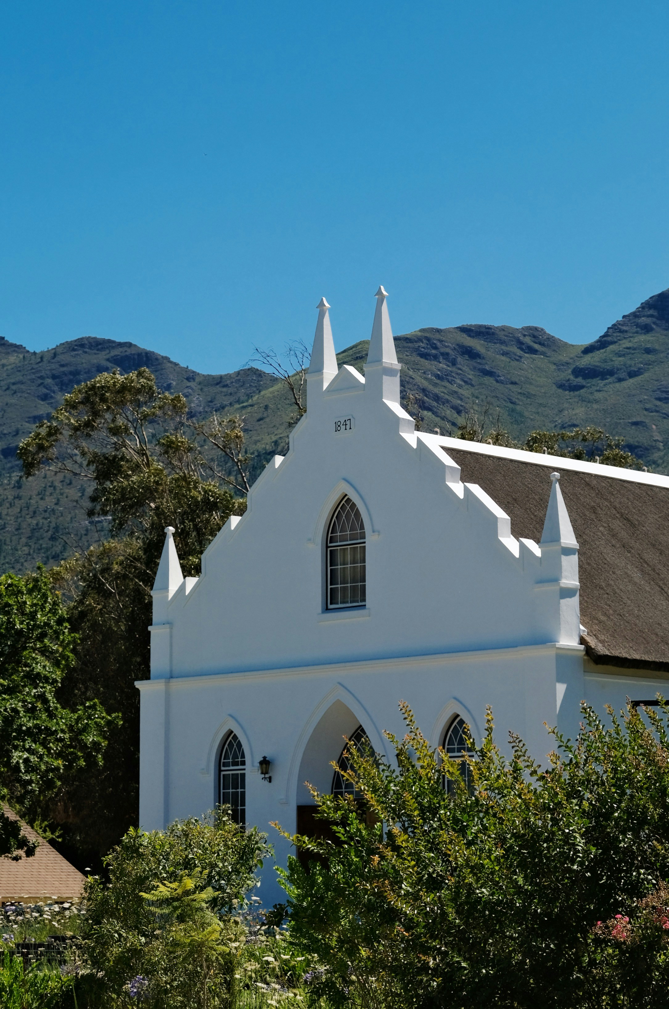 A white church with mountains in the background
