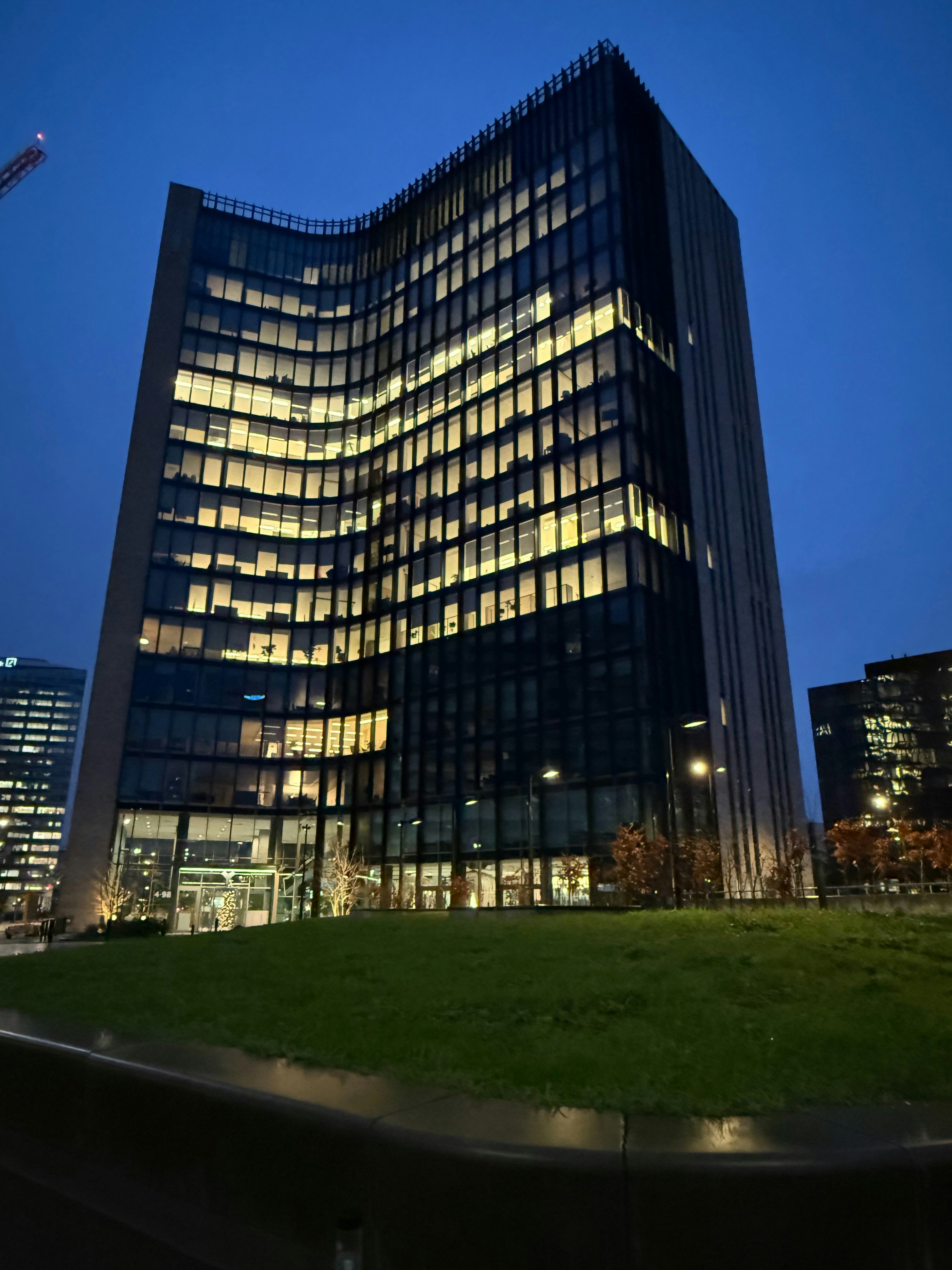 Modern bank building with glass facade in dim blue evening light with dark shadows