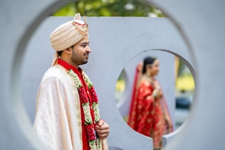 A man in a white turban standing in front of a mirror