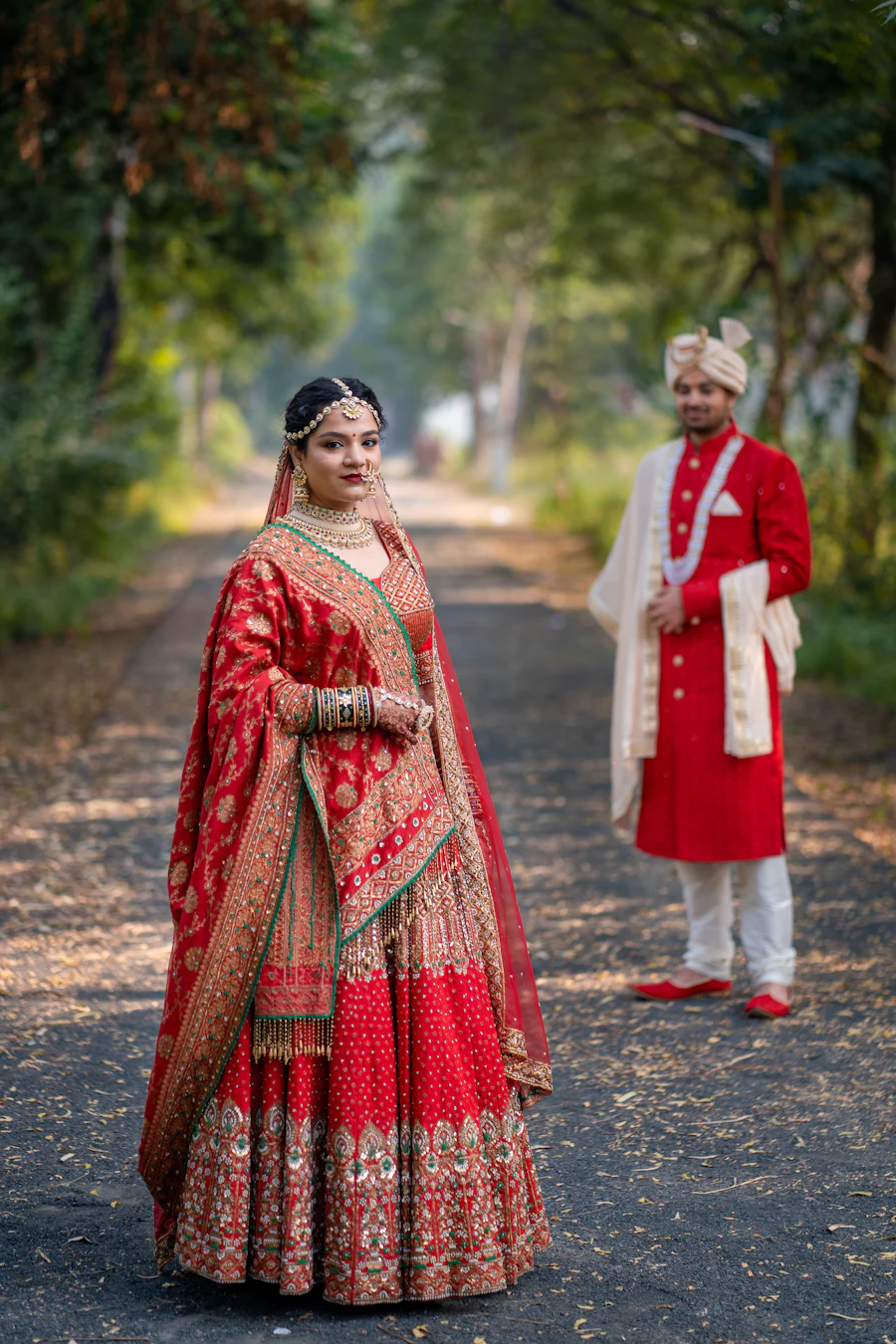 A man and woman dressed in Indian attire standing on a road