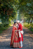 A bride and groom standing on a path in the woods