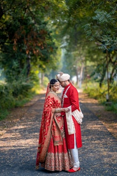 A bride and groom standing on a path in the woods