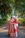 A bride and groom standing on a path in the woods