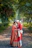 A bride and groom standing on a path in the woods