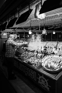 A man standing in front of a display of fish