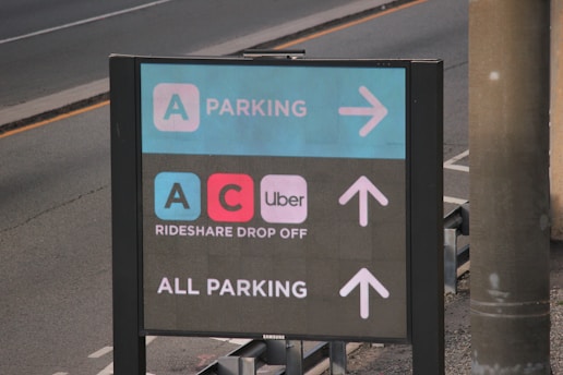 A parking sign on the side of the road, drop off zone