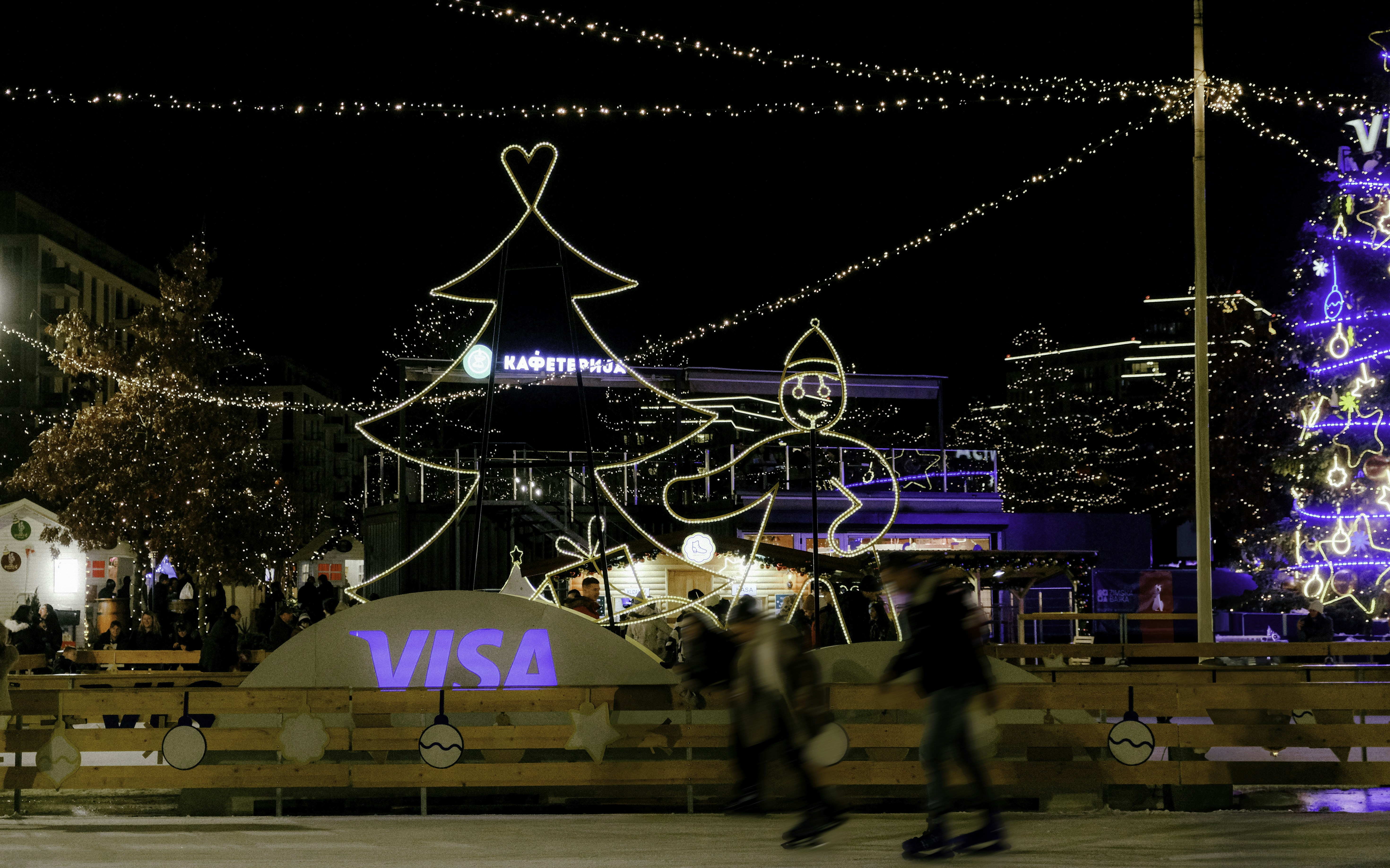 A couple of people riding skateboards down a street