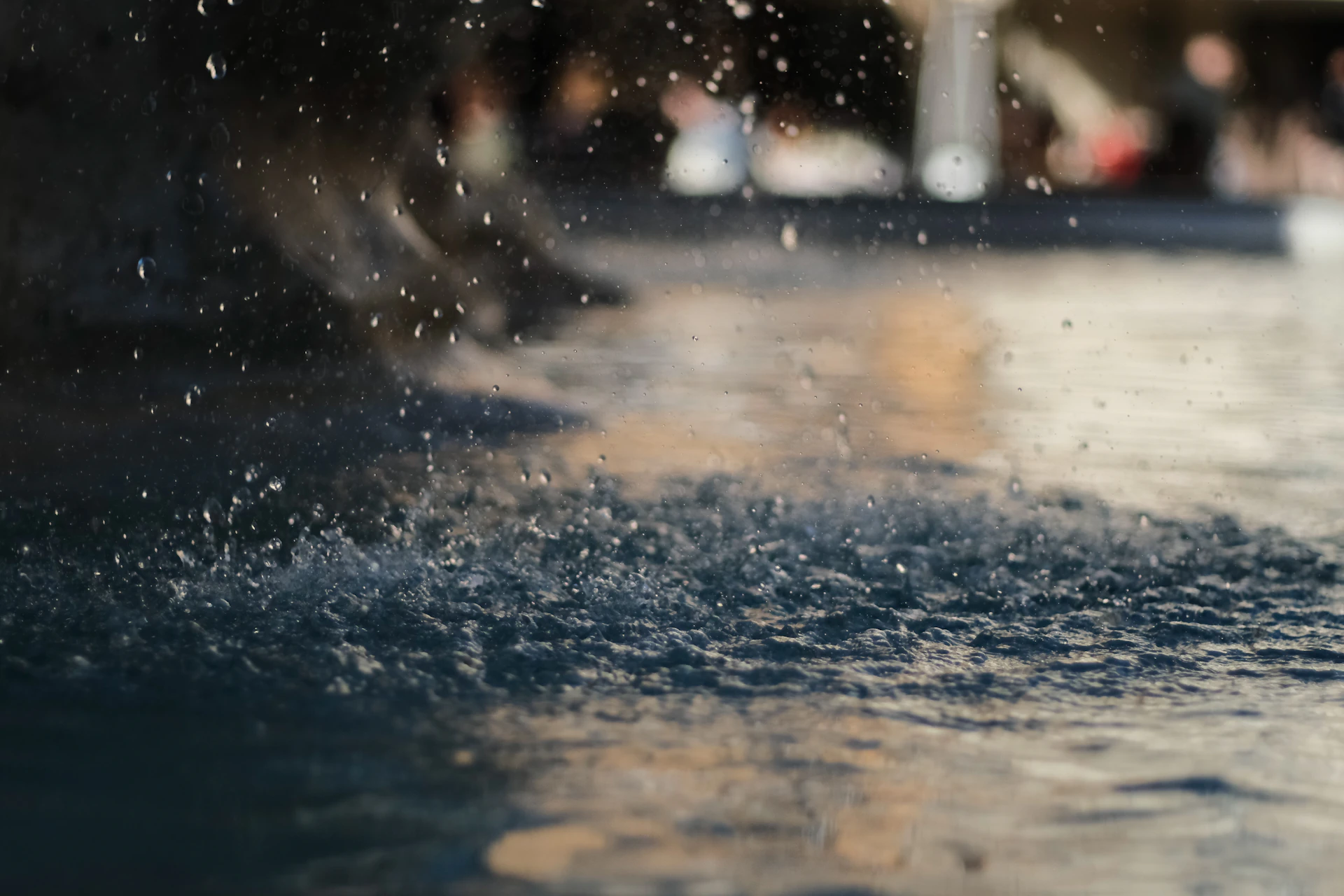A close up of a water fountain with people in the background