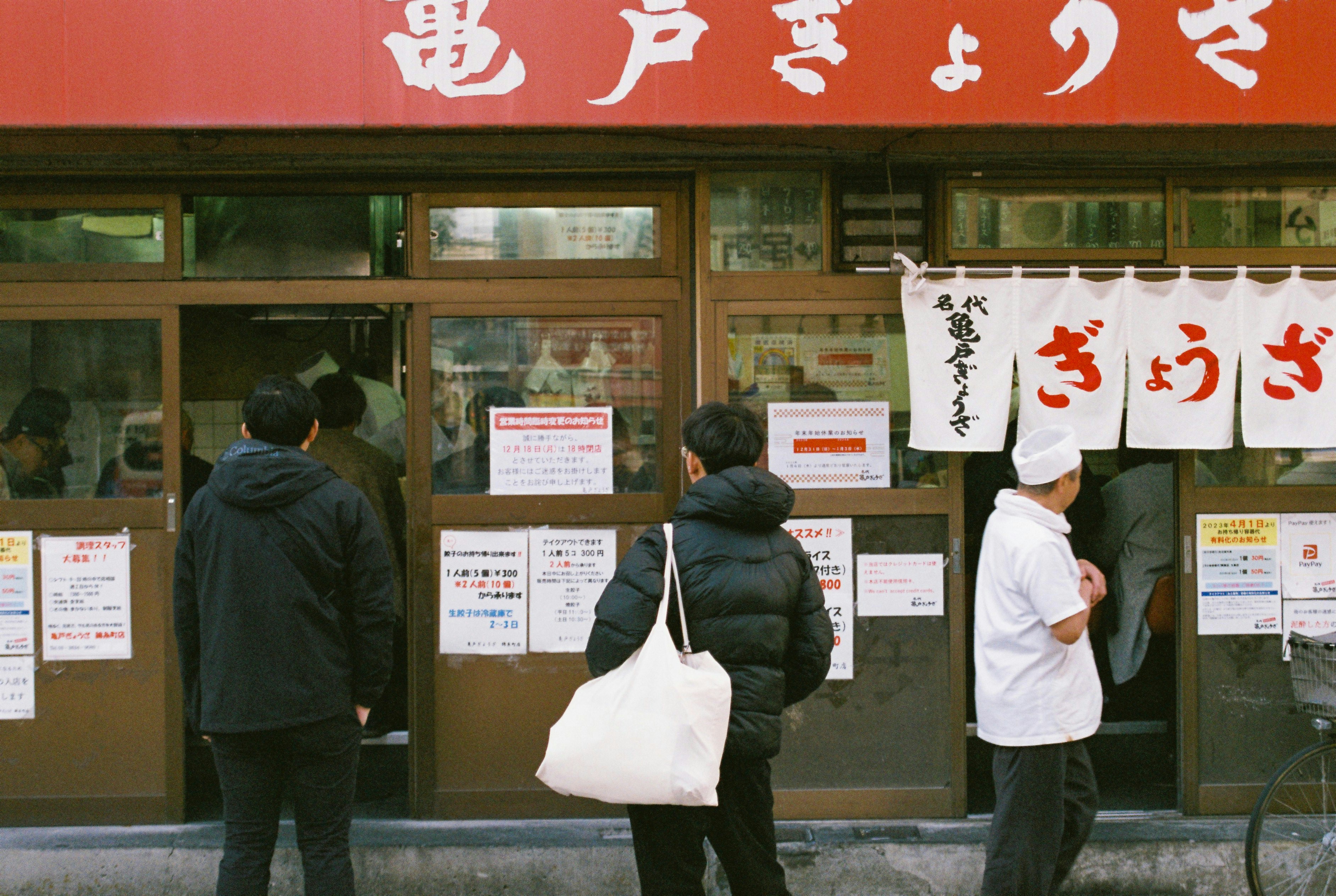 A group of people standing outside of a store