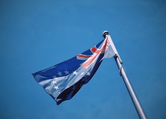 A flag flying in the wind with a blue sky in the background