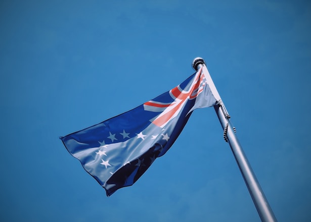 A flag flying in the wind with a blue sky in the background
