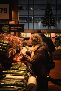 A woman standing in front of a display of vegetables