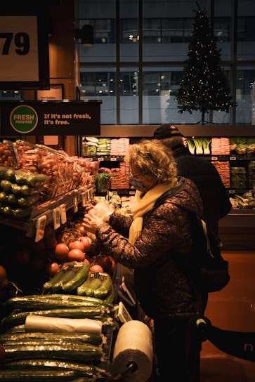 A woman standing in front of a display of vegetables