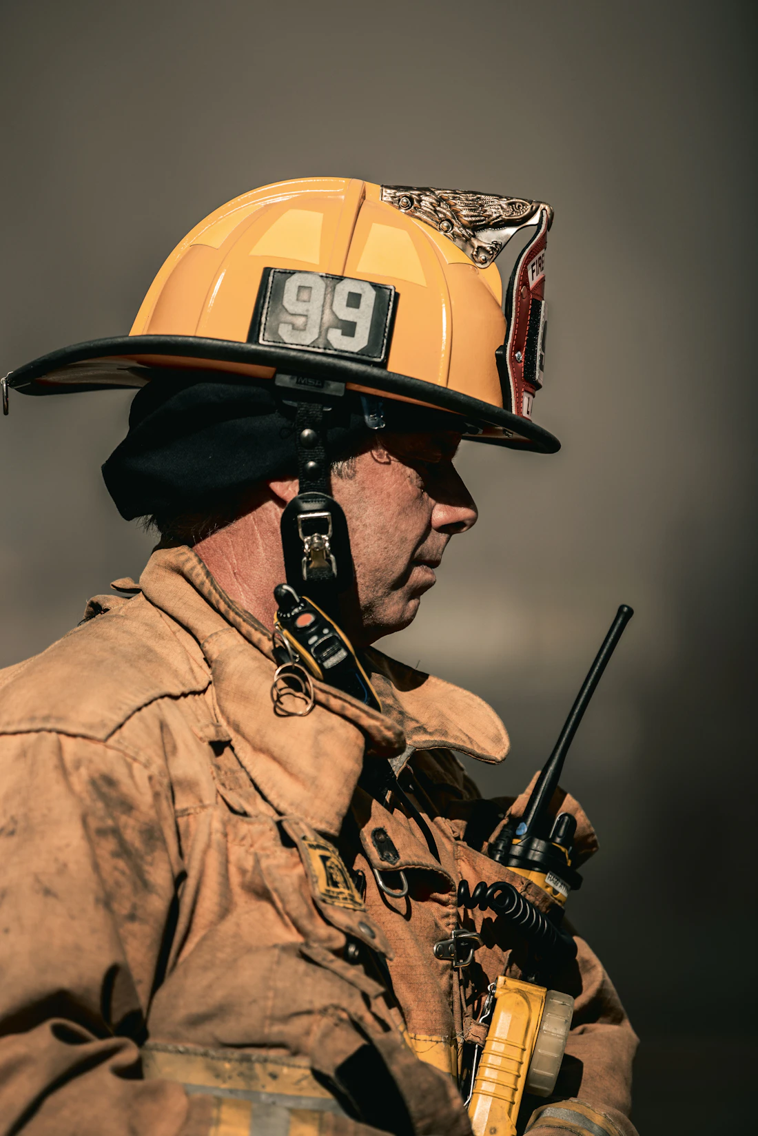 A firefighter in helmet holding a radio