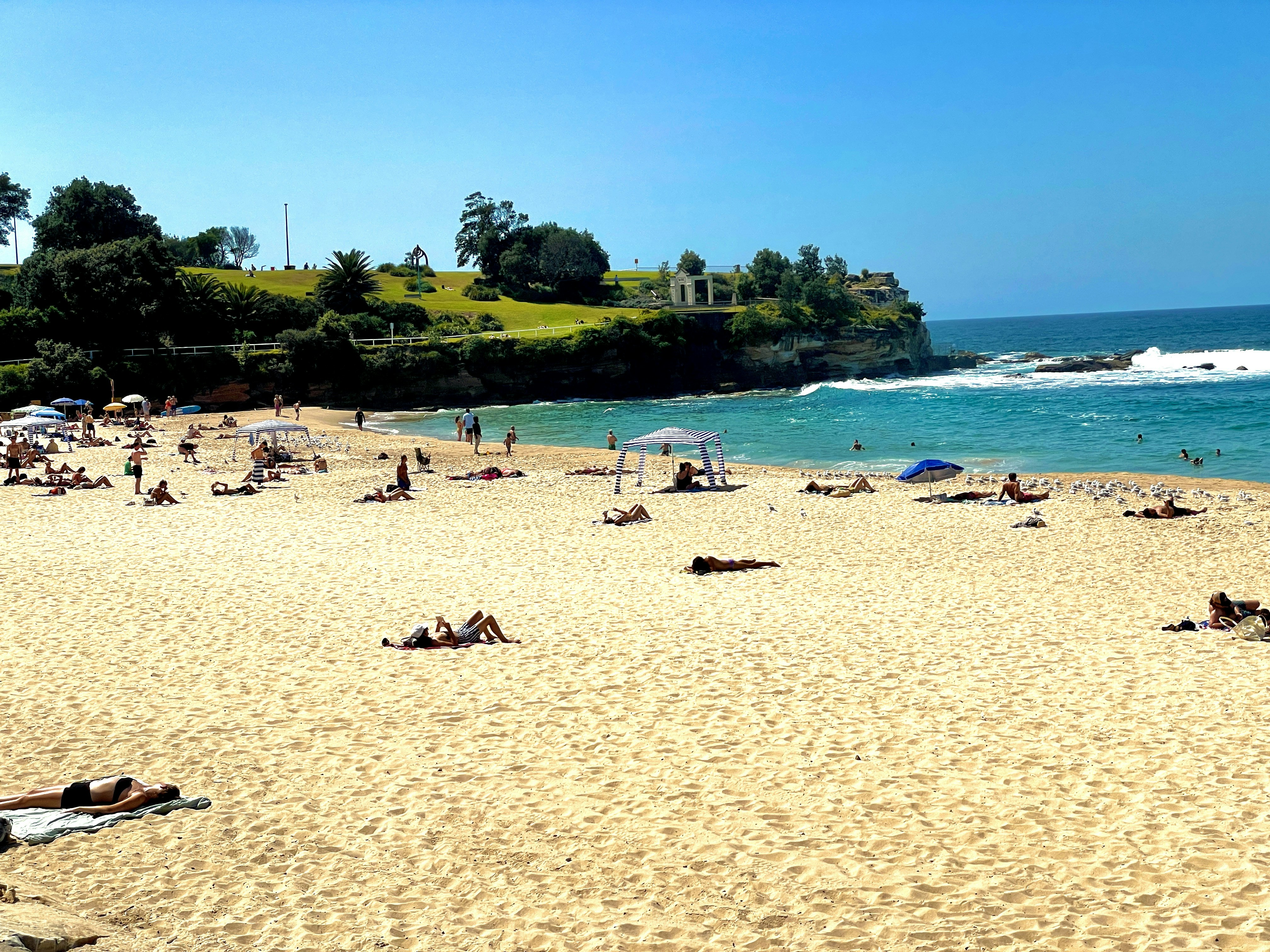 Pantai yang ramai dengan orang-orang berbaring di atas pasir