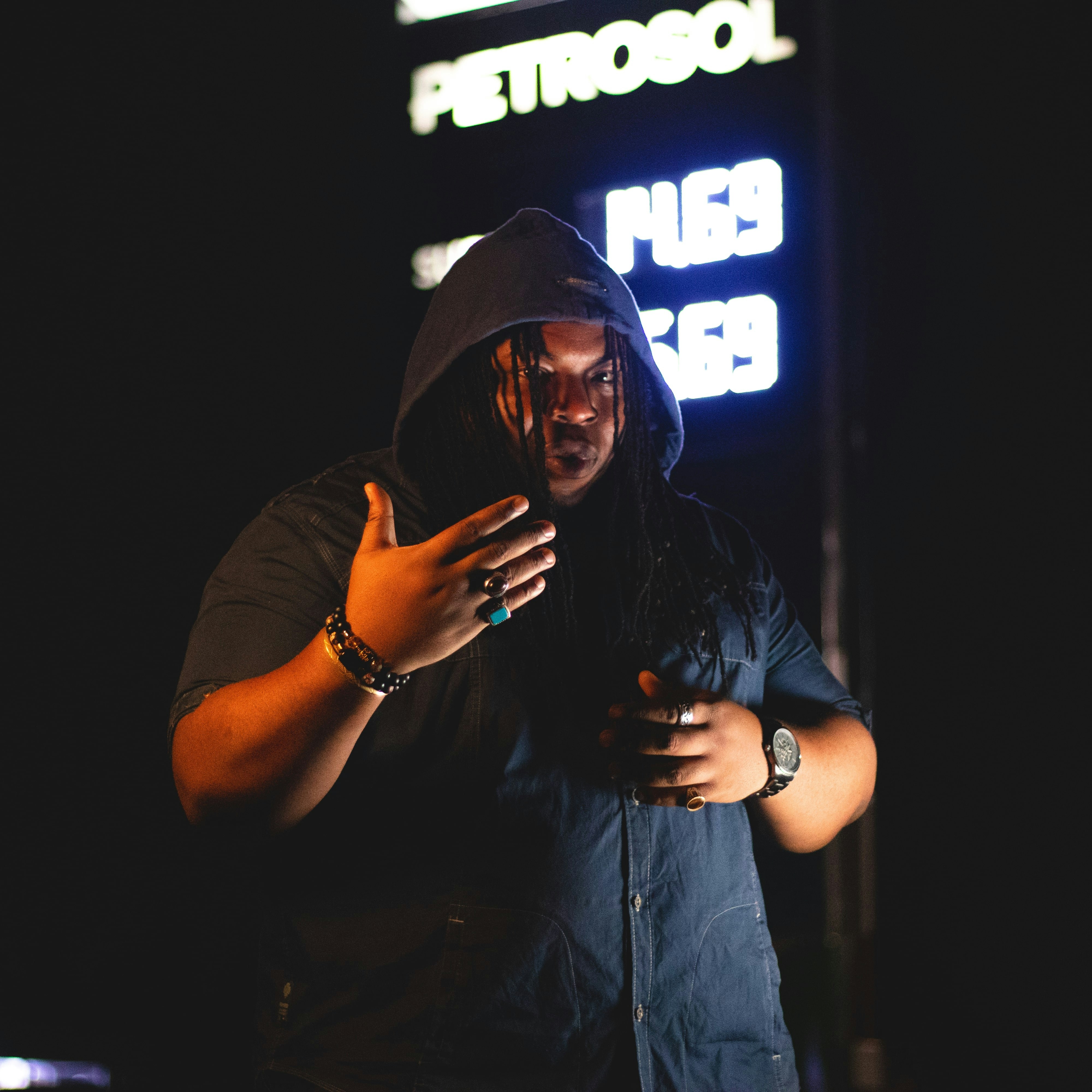 A man in a hoodie looking at his cell phone