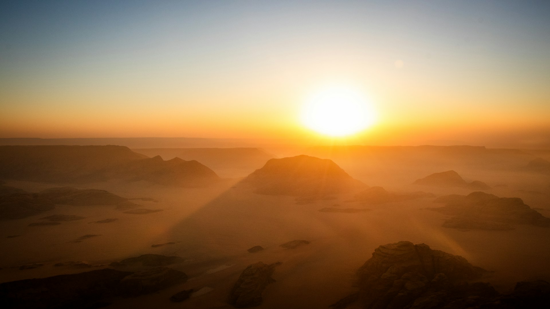 The sun is setting over a mountain range