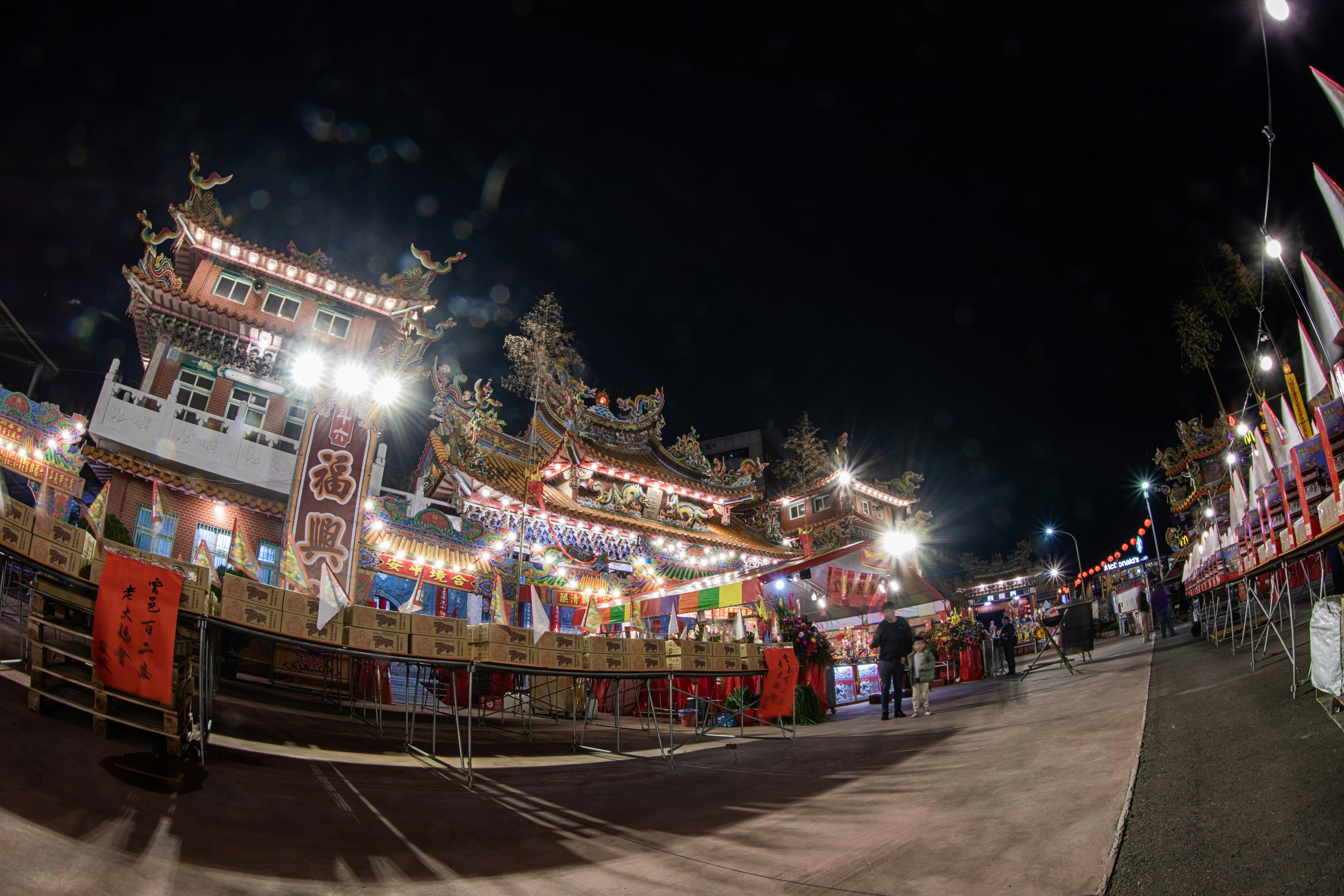 A group of people standing around a carnival at night