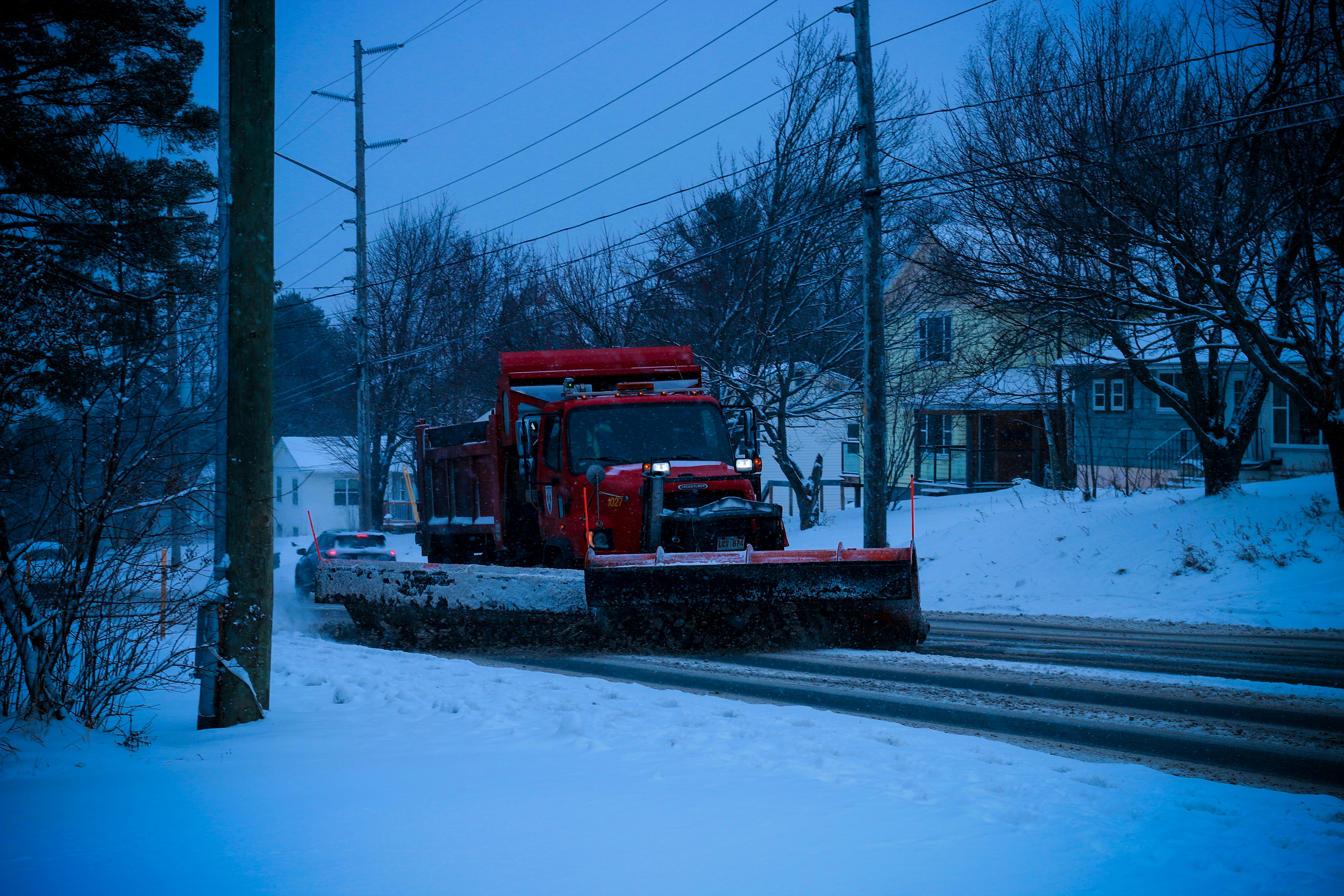 A snow plow on the side of a snowy road
