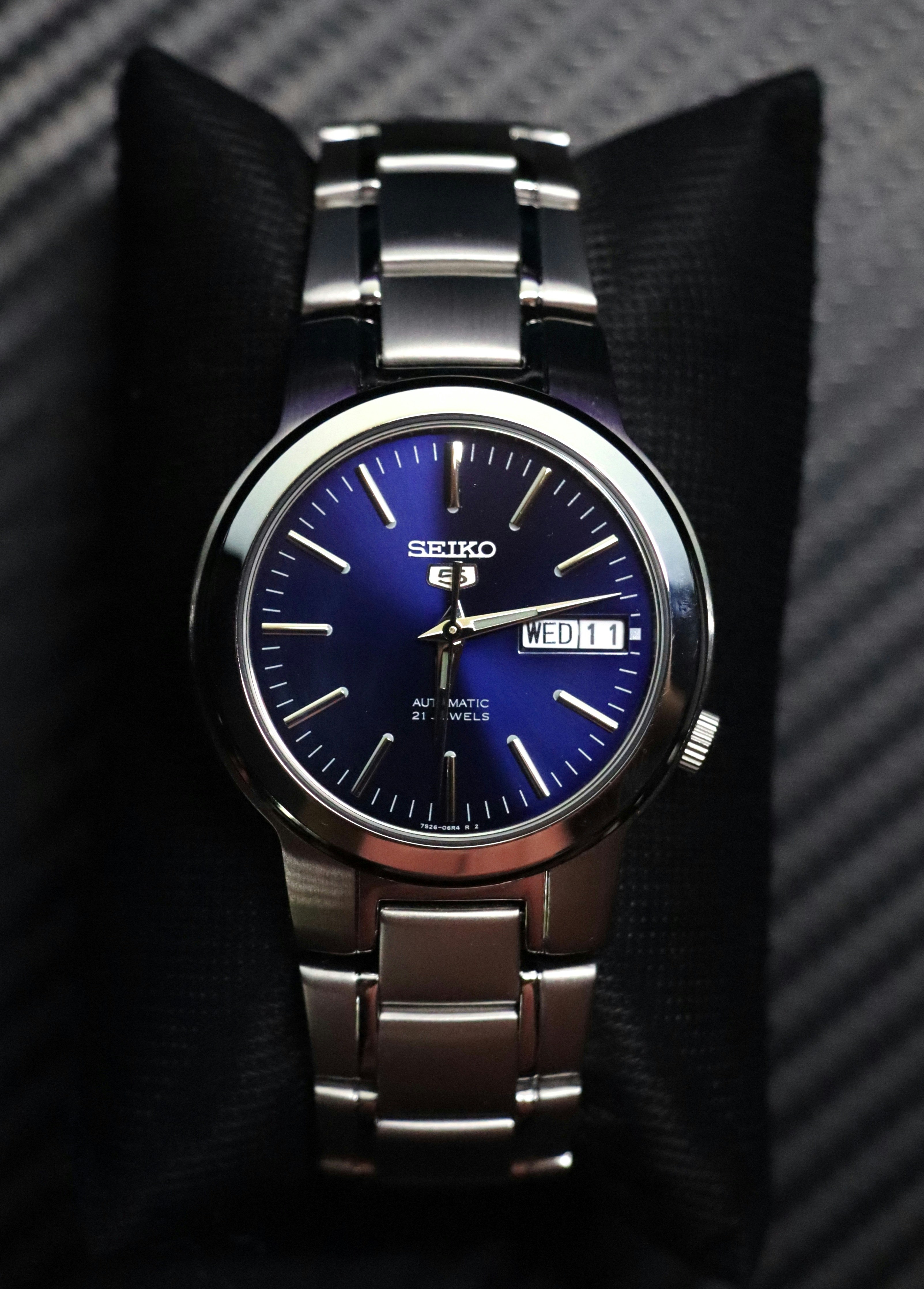 A close up of a watch on a black surface