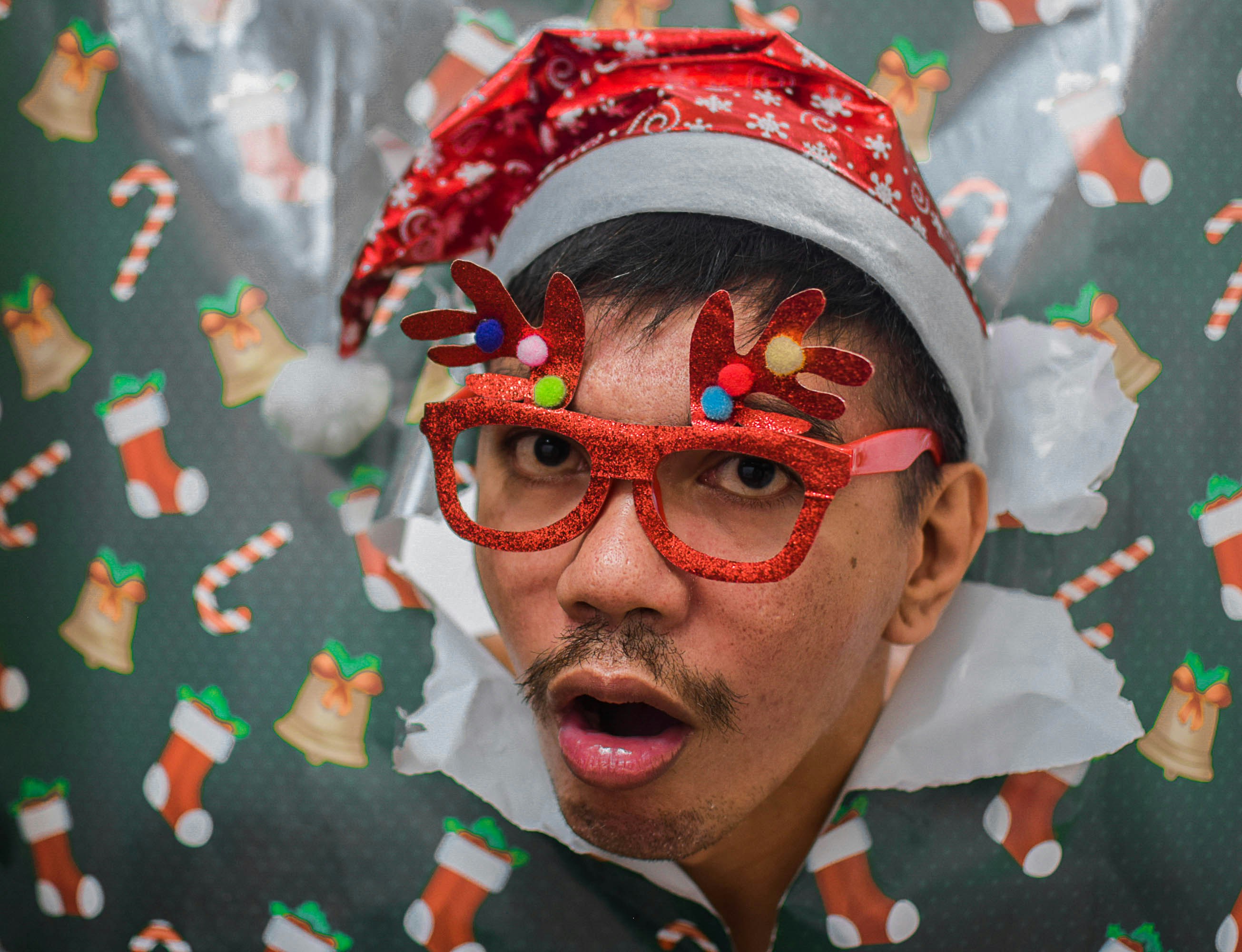 A man wearing a santa clause hat and glasses