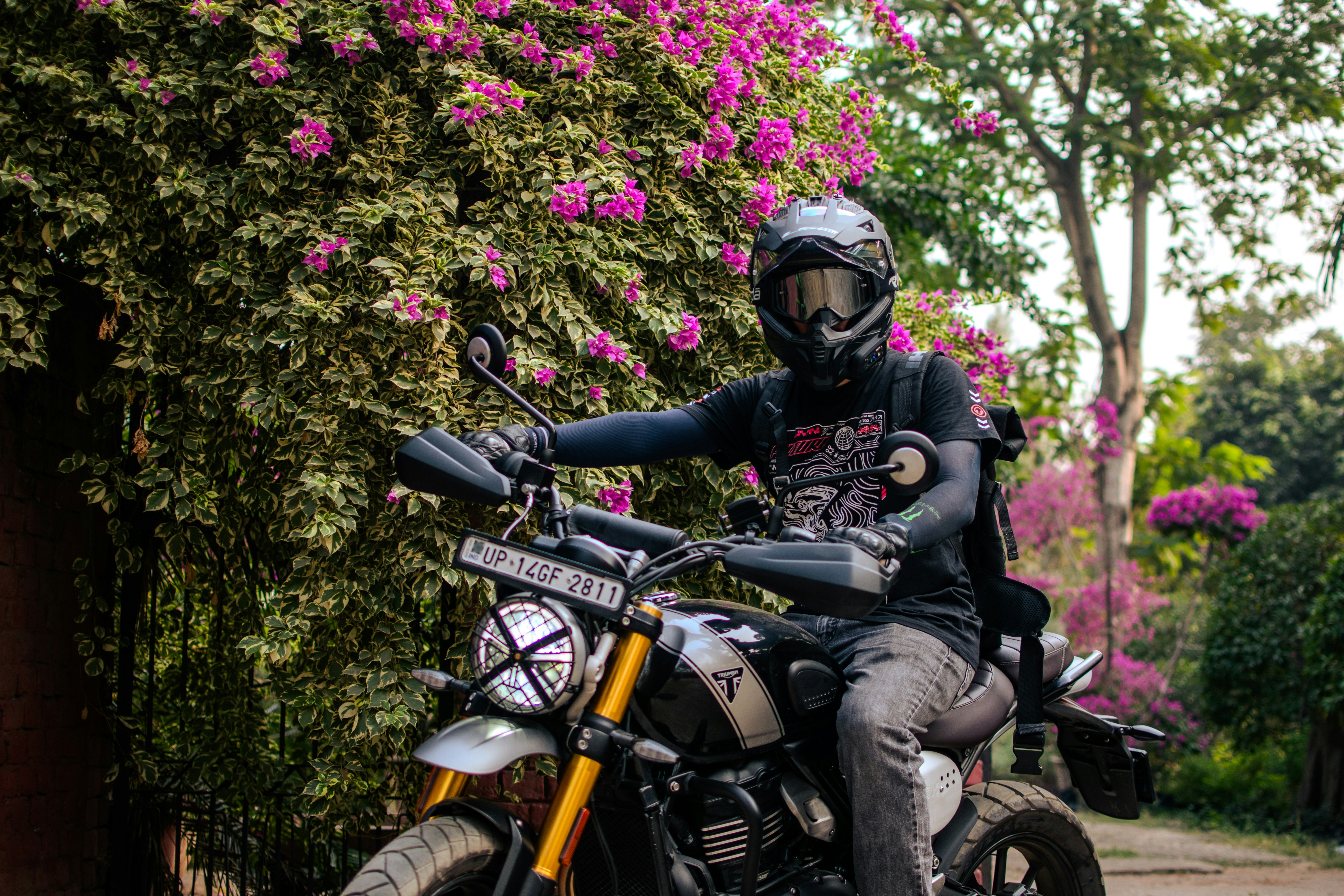 Un uomo che guida sul retro di una motocicletta lungo una strada