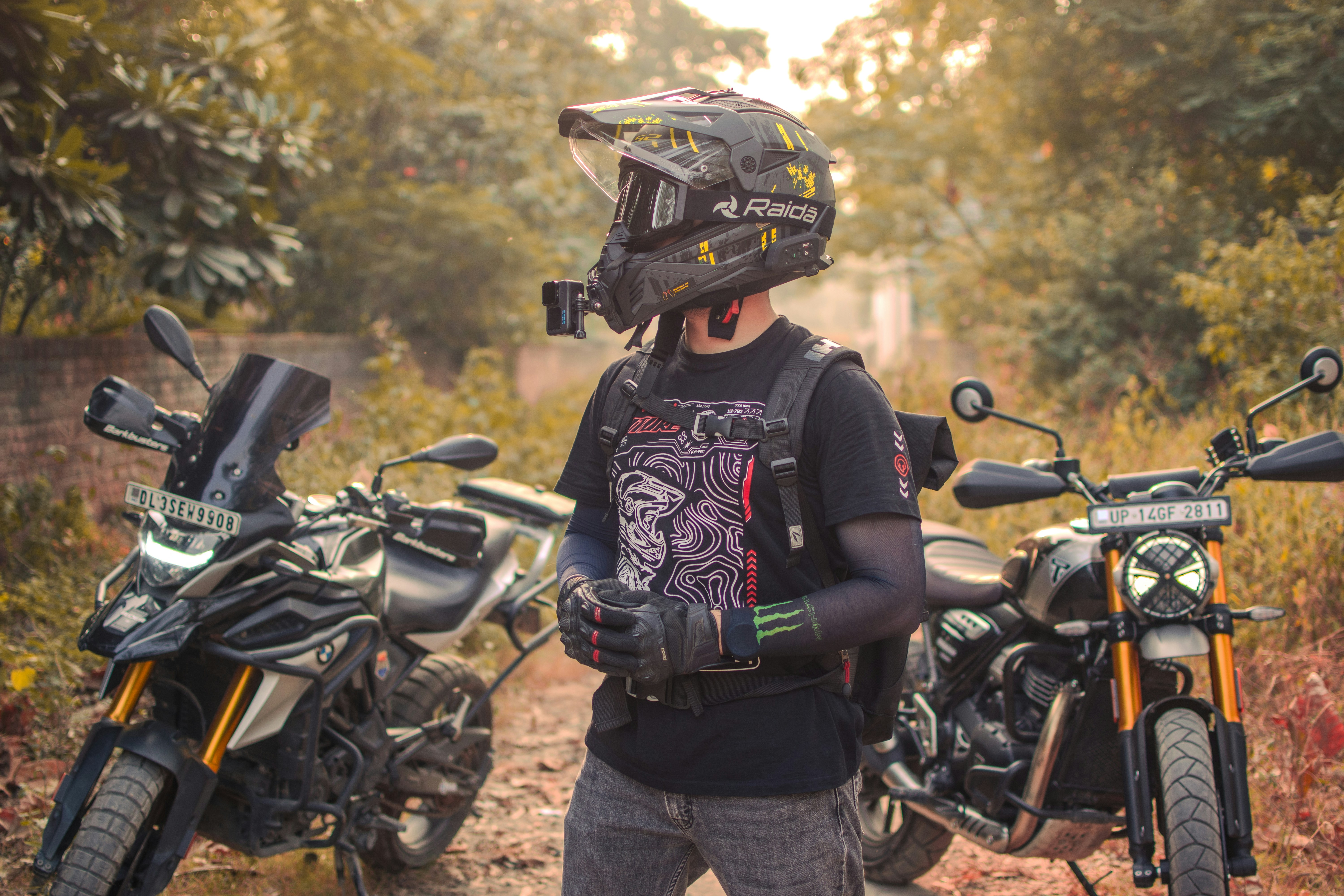 Un uomo, in piedi accanto a due motociclette parcheggiate