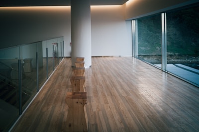 An empty room with a wooden floor and glass walls