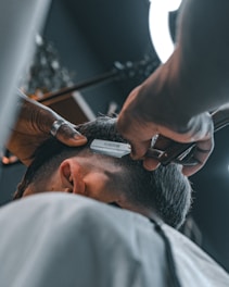 A man getting his hair cut at a barber shop