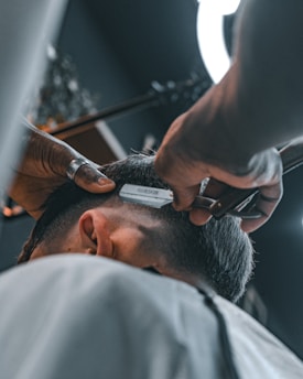 A man getting his hair cut at a barber shop