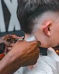 A man getting his hair cut at a barber shop