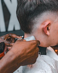 A man getting his hair cut at a barber shop