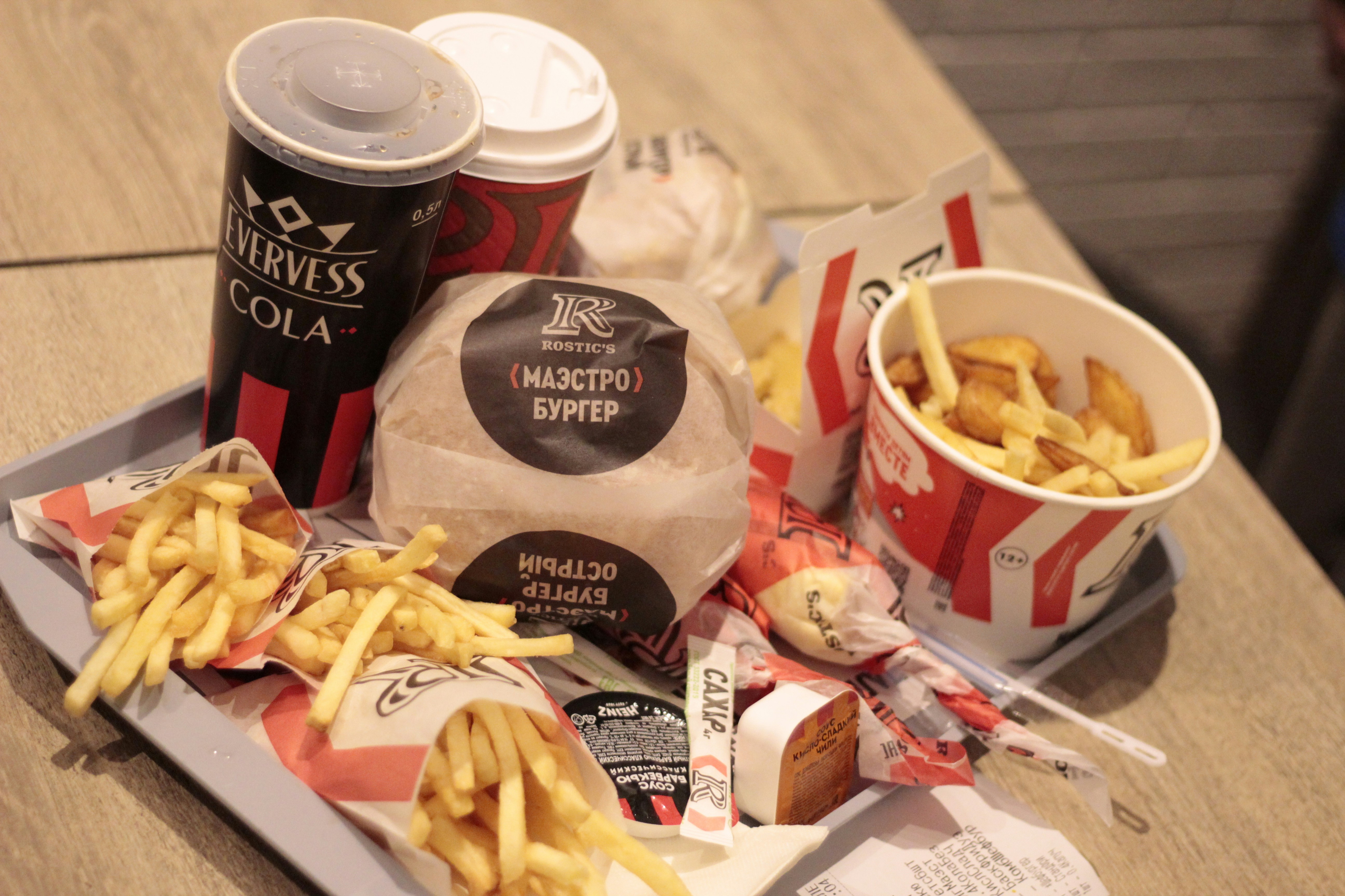 Combo de hamburguesa, papas y bebida presentado en bandeja