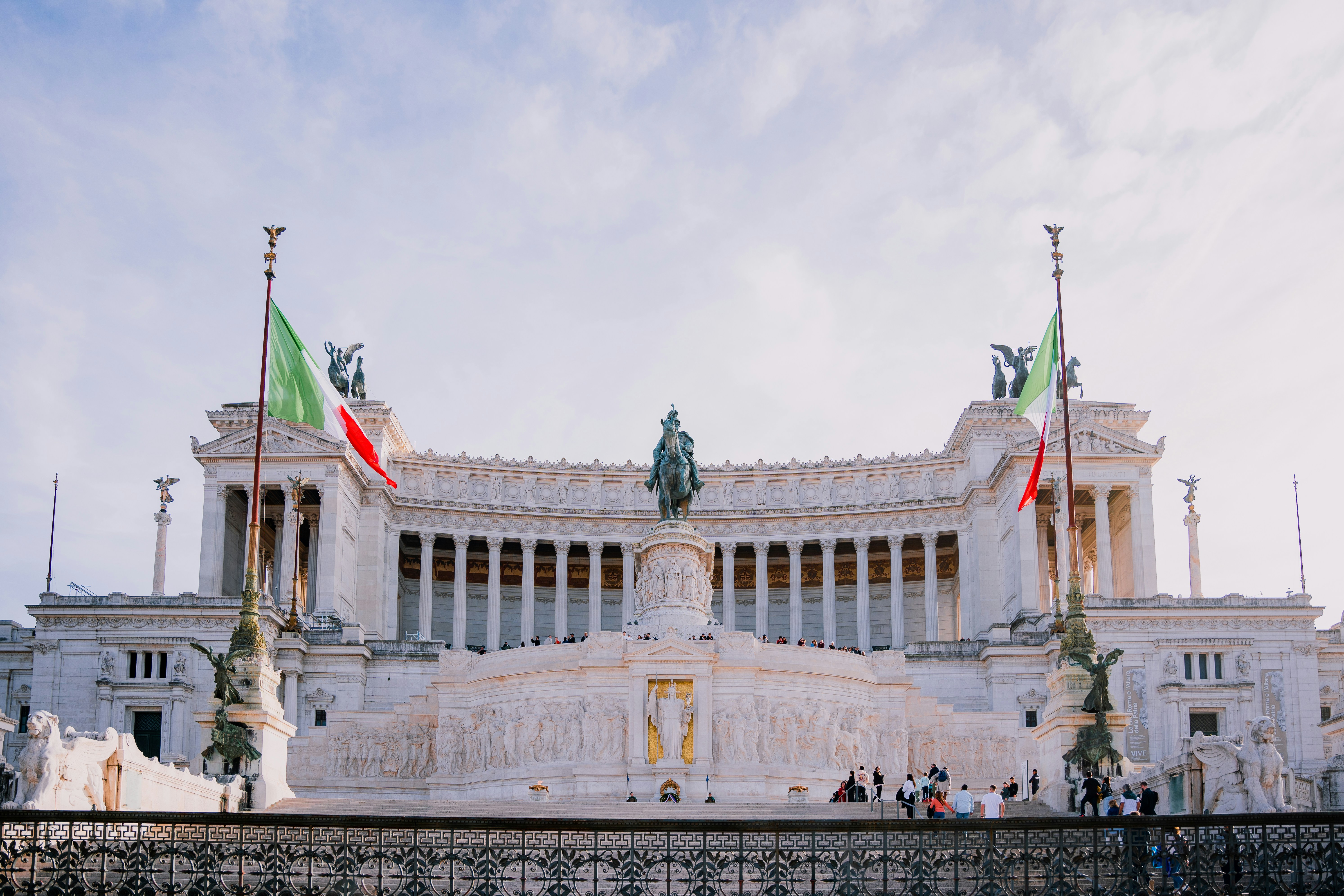 A large white building with two flags in front of it
