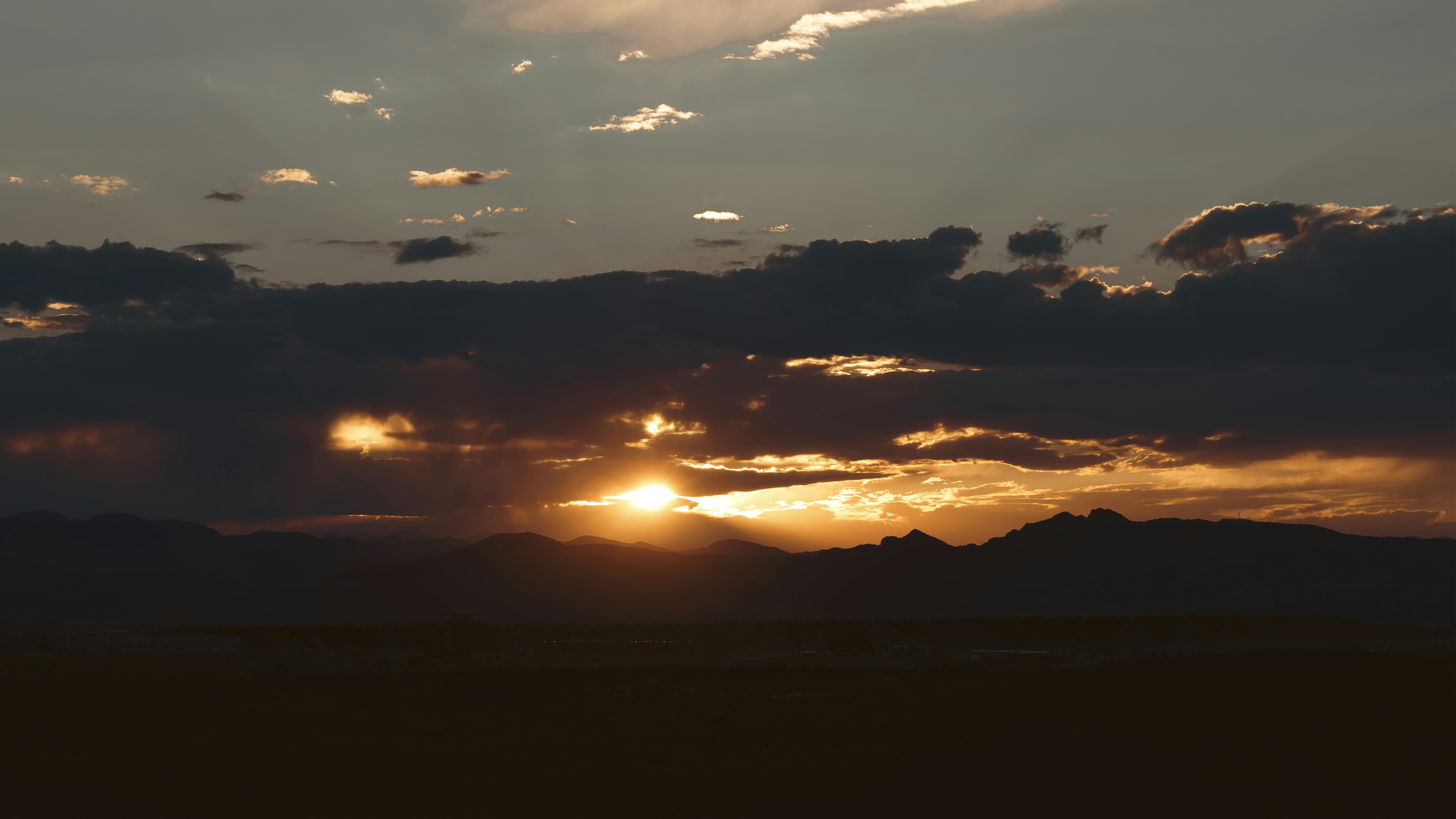 The sun is setting over a mountain range