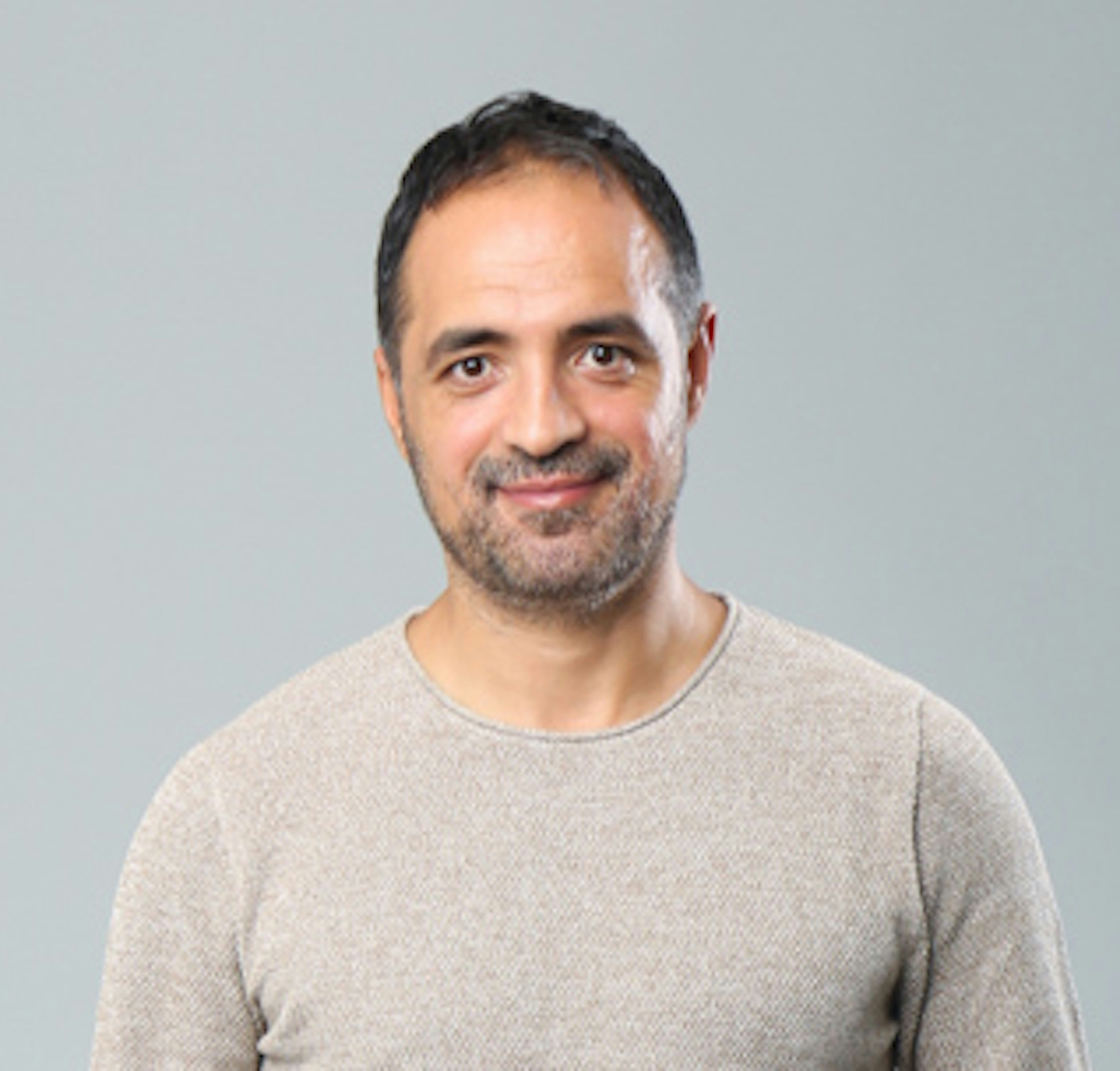 Marcus, a man with a warm smile against a neutral background