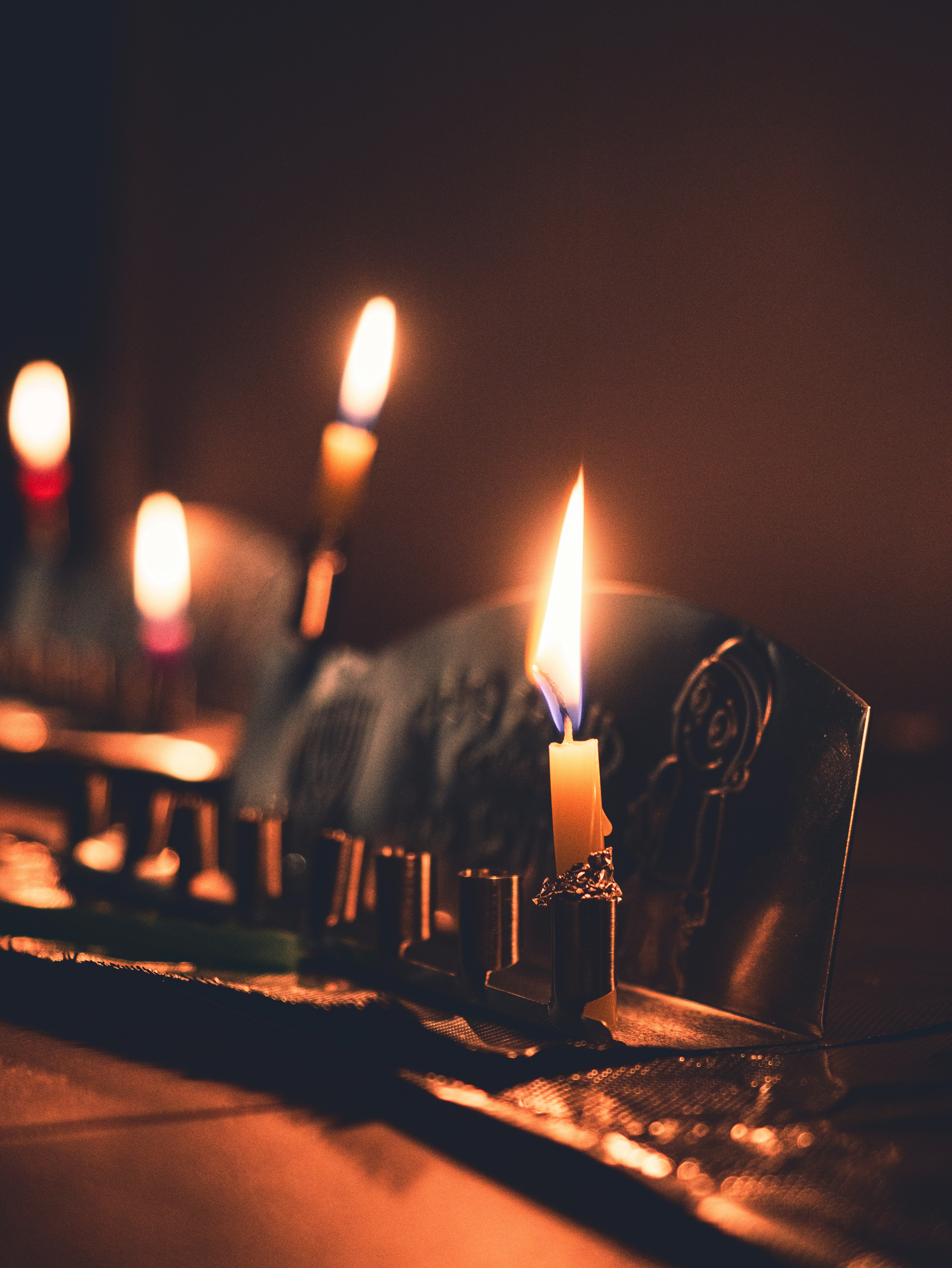 Eine Reihe brennender Kerzen sitzt auf einem Tisch