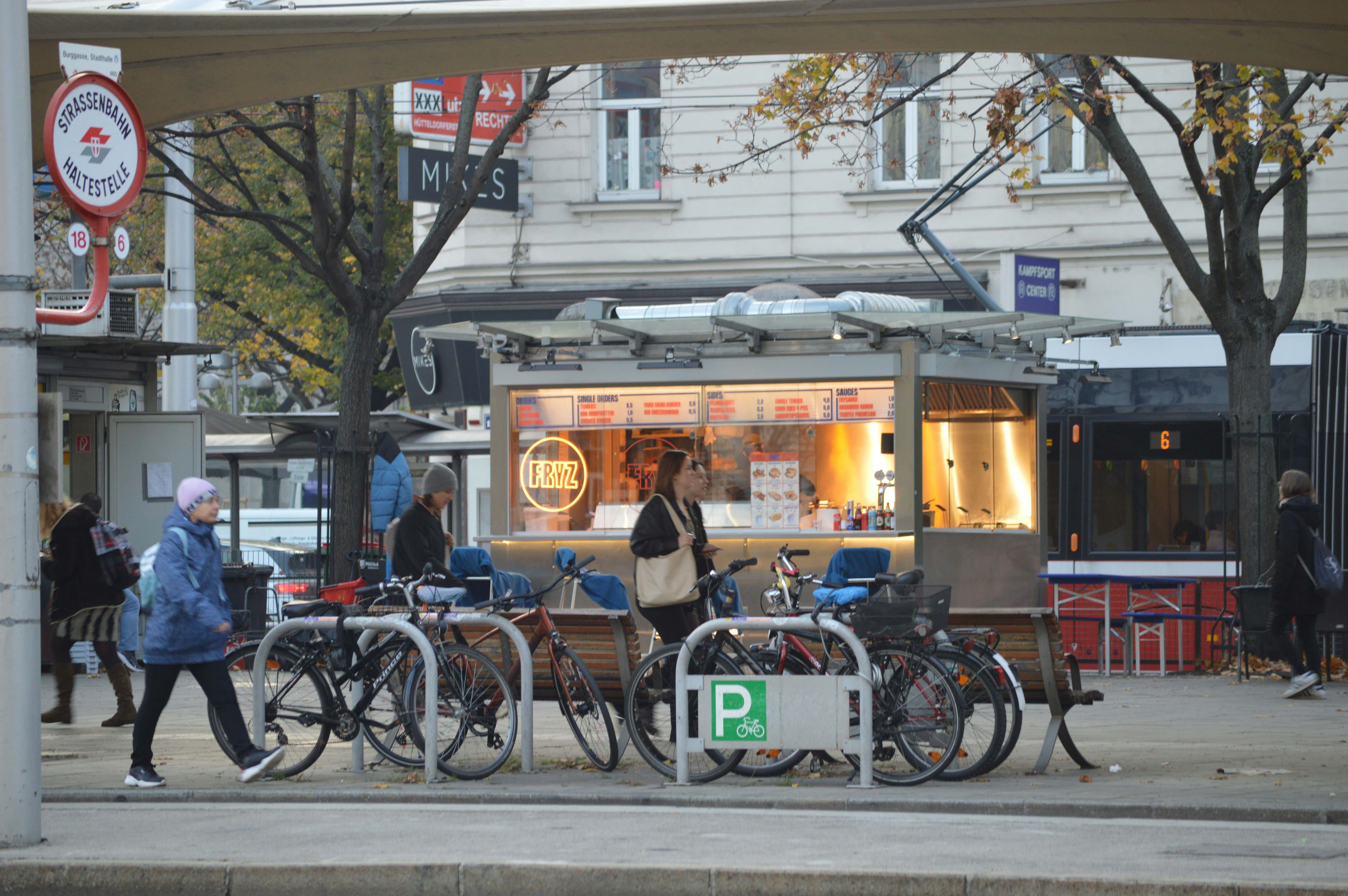A group of people walking down a street next to parked bikes, Vienna City Sightseeing Tour