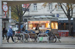A group of people walking down a street next to parked bikes