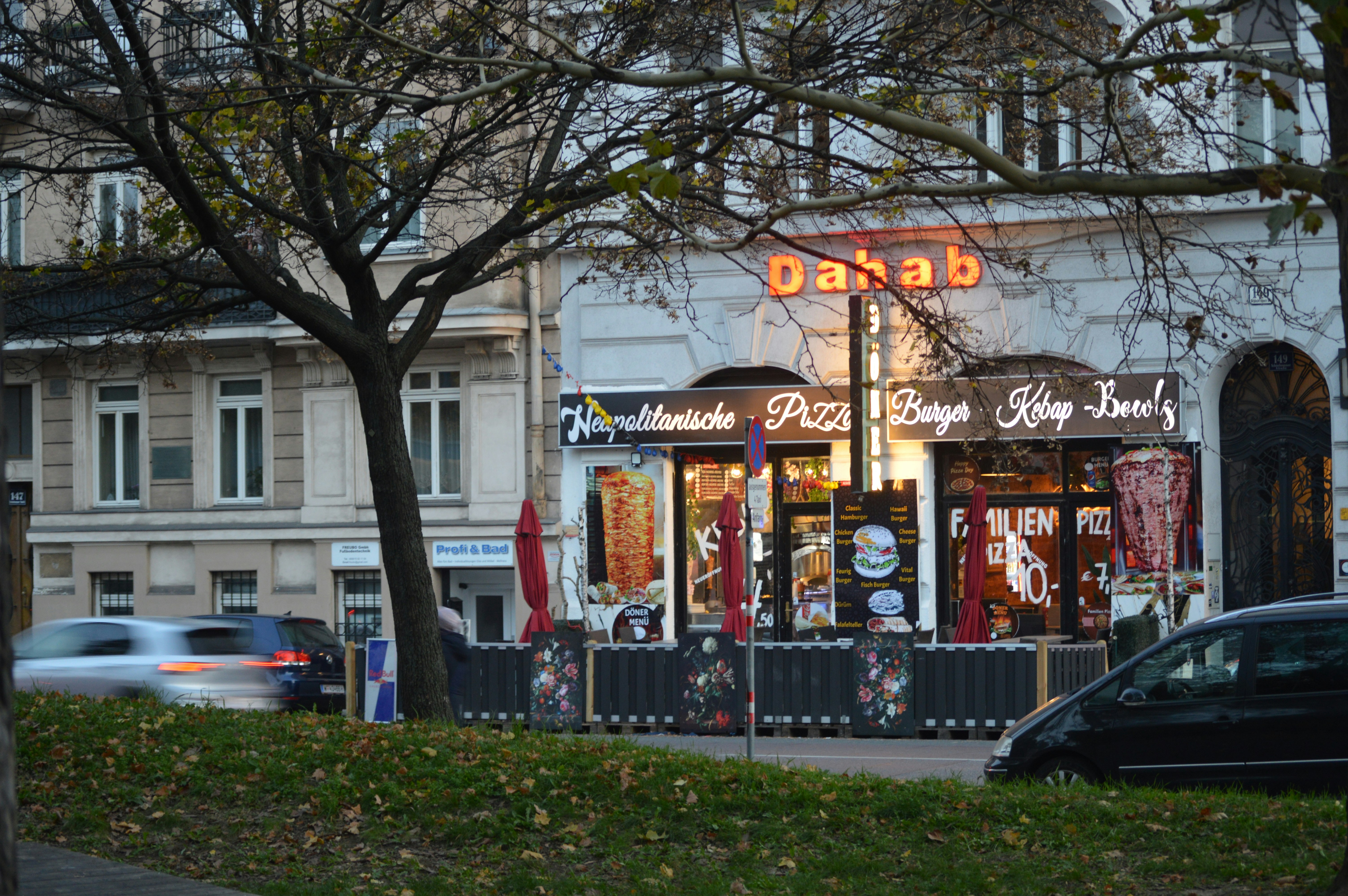 A street corner with cars parked on the side of the road