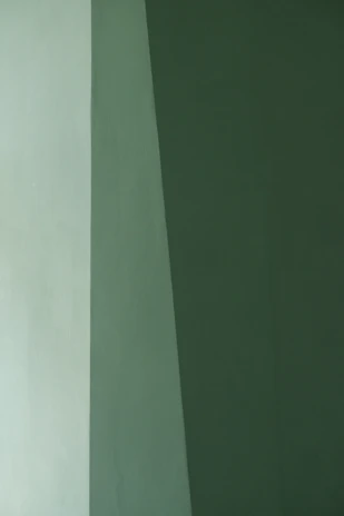 A man in a suit and tie standing in front of a wall